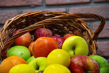 Fresh colorful fruits with water drops on them out of a basket