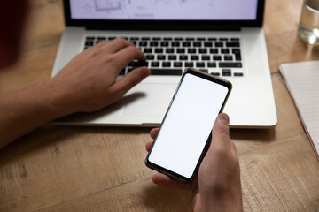  Caucasian man using a smartphone and laptop