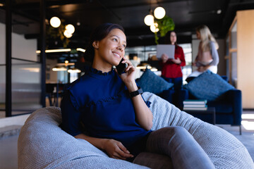 African American woman using her phone in modern office 