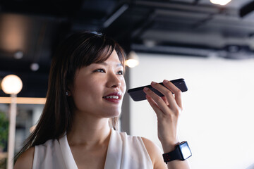 Asian woman talking to her phone and wearing digital watch