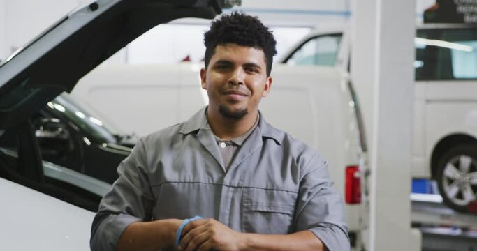 African American male car mechanic cleaning his hands with a rag and looking at the camera 