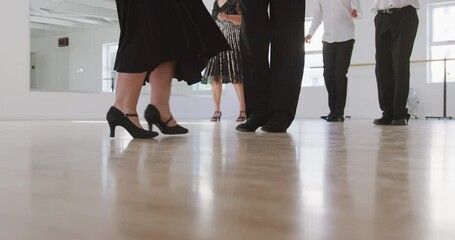 mixed race male dance teacher taking a ballroom dancing class at a dance studio - Powered by Adobe
