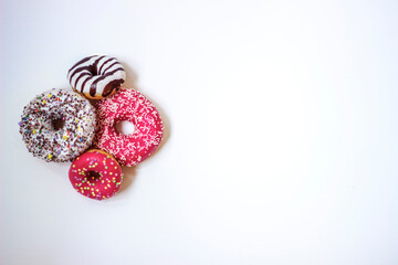 Colorful donuts on white background. Group of glazed donuts isolated on white background. Top view of beautiful donuts, space for text.