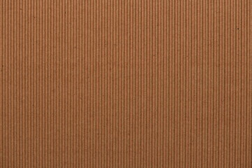 Corrugated light brown cardboard surface closeup background