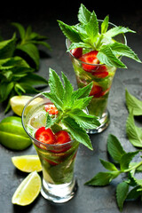 Citrus beverage with mint, berries and lime, summer cold drink in glass