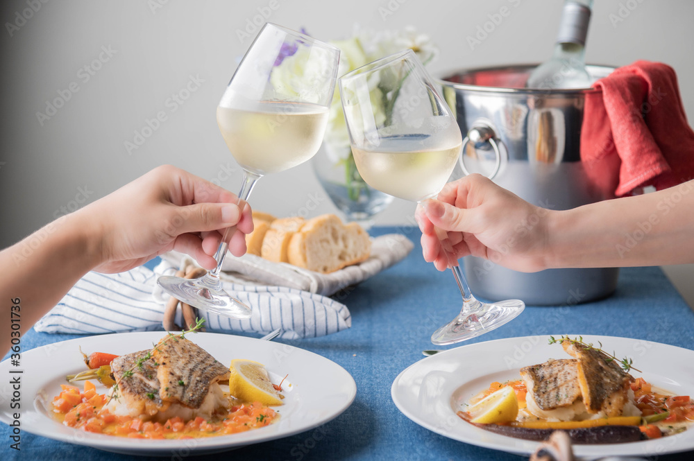 Poster toasting with white wine over the luxury seafood dish