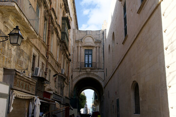 Fototapeta na wymiar VALLETTA, MALTA - DEC 31st, 2019: Typical narrow cozy street in Valletta, Malta. Old architecture. Traditional maltese architecture