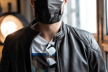 Young man in protective face mask as preventive measure from coronavirus COVID-19. Personal...