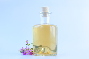Obraz na płótnie Canvas Essential oil of Arabis flower on a White background in beautiful bottle