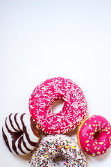 Top view of four donuts on white background. Glazed donuts or doughnuts set - various colors and tastes 3d rendering. Cute, colorful and glossy donuts with glaze and powder.