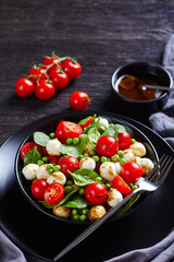 Italian caprese salad with peas and baby spinach