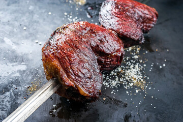 Barbecue dry aged wagyu Brazilian picanha from the sirloin cap of rump beef offered as closeup on a...