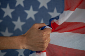 Naklejka premium Close-up of dark-skinned female hand clutching usa flag