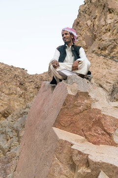 A bedouin sitting in a rock in the mountains near nuweiba