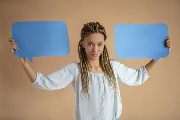 Smiling young African American female rising two blue dialogue clouds above her head