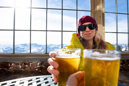 A woman toasting to a day on the slopes. - Powered by Adobe