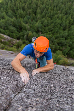 Climber looking up really focused on next hard move while climbing