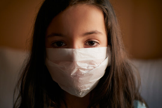 Girl with face mask in quarantine at home for covid-19 coronavirus