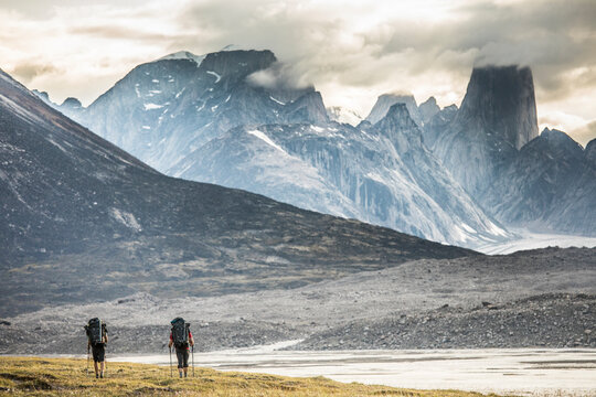 Two backpacks hike toward Mount Asgard in Akshayak Pass, Baffin Island