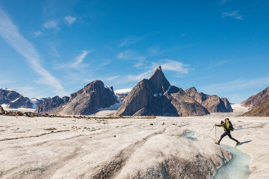 Mountaineer crosses a river on the Caribou Glacier, Baffin Island