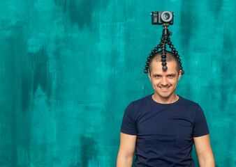 Fototapeta na wymiar Funny man blogger, photogapher and videographer with camera on his head