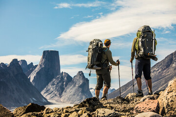 Two Backpackers look out at view from mountain ridge.