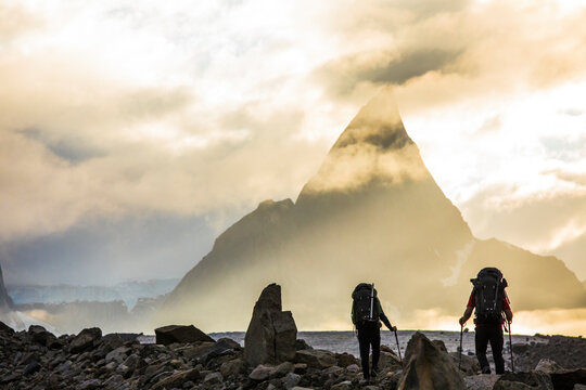 Rear view of backpackers approaching dramatic mountain, Mt. Loki