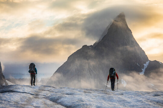 Two backpackers hiking towards Mt. Loki, Baffin Island, Canada.