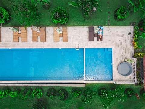 Aerial view of attractive woman near the pool at resort