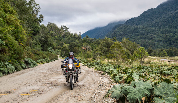 Man driving on a touring motorbike gravel road on  Carretera Austral