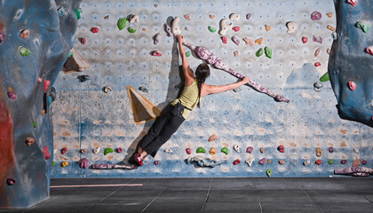 mature woman practising at indoor climbing wall in the UK