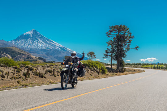 Woman on touring motorbike. Lanin volcano in the back, Argentina
