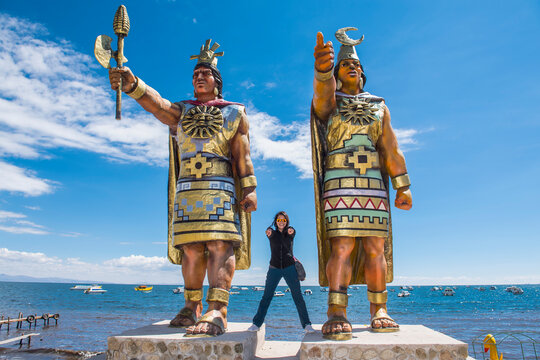 Woman posing at statues of Sun God and Moon Goddess, Lake Titicaca