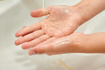 washing children's hands under the tap. No COVID-19 