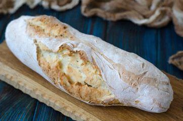 Crispy baguette with cracks on the board