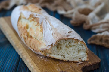Crispy baguette with cracks on the board