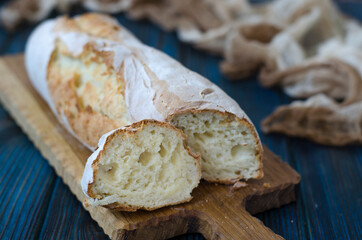 Crispy baguette with cracks on the board