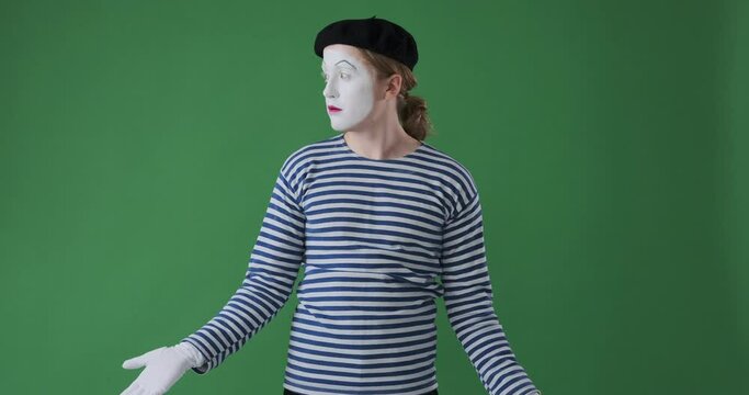 Confuse mime artist man looking around over green background