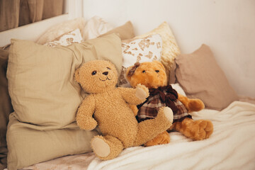 Teddy bear sitting on wooden baby bed against brick wall