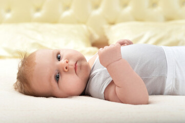 Portrait of cute little baby girl on bed