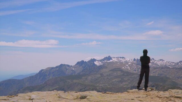 Hiker admires the crest of the snowy mountain