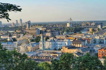 Fototapeta na wymiar Kyiv skyline, panorama view of the city and river, bridge. Green trees, Ferris wheel, and old cathedrals. Kyiv/Kiev Ukraine. 