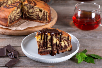 Homemade marble cake (zebra) with a cup of tea on rustic table