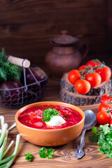 Borscht. Red soup in bowl with sour cream on wooden background. National ukrainian or russian red soup