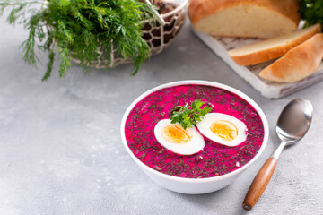 Summer Cold beetroot soup with fresh vegetables and boiled egg on a concrete background. Place for text