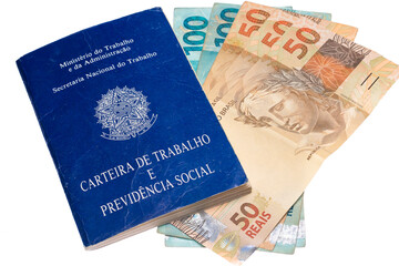 .Brazilian work and social security portfolio with several Brazilian money bills and coins photographed on white background