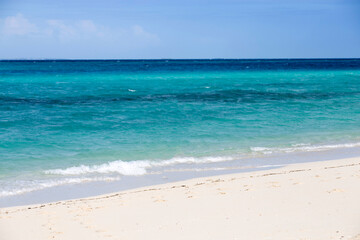 Fototapeta na wymiar Clean white sand beach with turquoise water . Tropical island background. Small waves crushing on the beach. Clean empty white sand beach on Zanzibar. Small waves crushing on the beach.