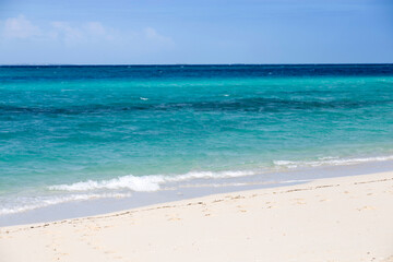 Obraz premium Clean white sand beach with turquoise water . Tropical island background. Small waves crushing on the beach. Clean empty white sand beach on Zanzibar. Small waves crushing on the beach.