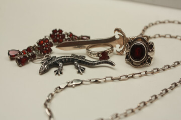 Silver pendant in the shape of a sword on an anchor chain, silver set of earrings and rings with...