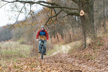 Fototapeta premium man rides a bicycle in the autumn at a high speed in nature